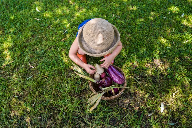 Petite fille dans le jardin avec des légumes