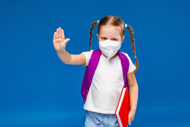 Petite fille dans un masque médical fait un geste d'arrêt