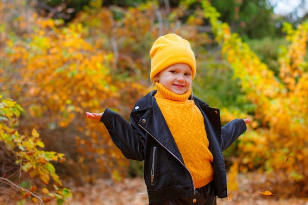 une petite fille dans un parc en automne