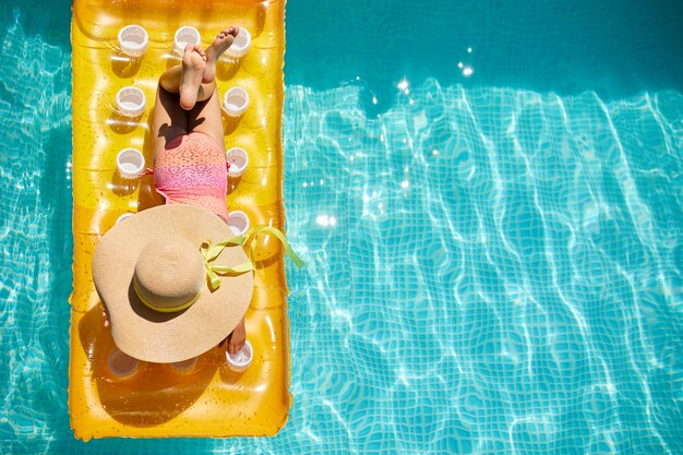 Petite fille dans la piscine sur un matelas gonflable