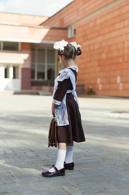 Petite fille dans la rue dans un uniforme vintage