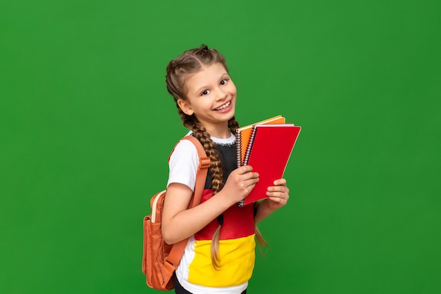 Une petite fille dans un T-shirt avec l'image du drapeau de l'Allemagne étudiant en Allemagne et apprenant l'allemand