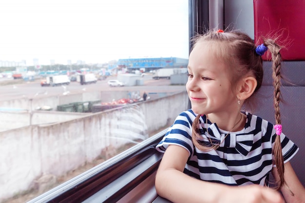 Petite fille dans le train regarde par la fenêtre