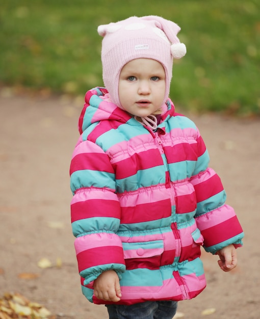 Petite fille dans une veste colorée à l'extérieur