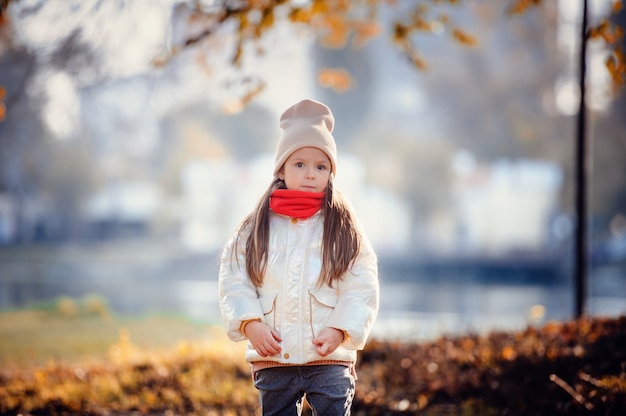 Petite fille debout devant la vue d'automne