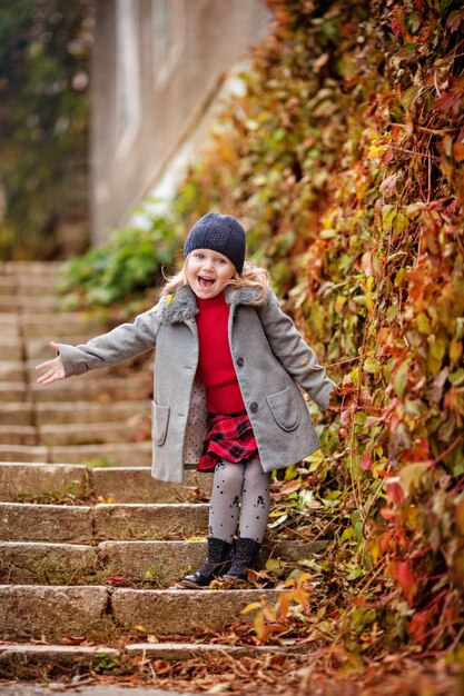 petite fille debout sur une marche dans le parc, bébé heureux