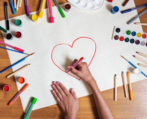 Petite fille dessin coeur en papier