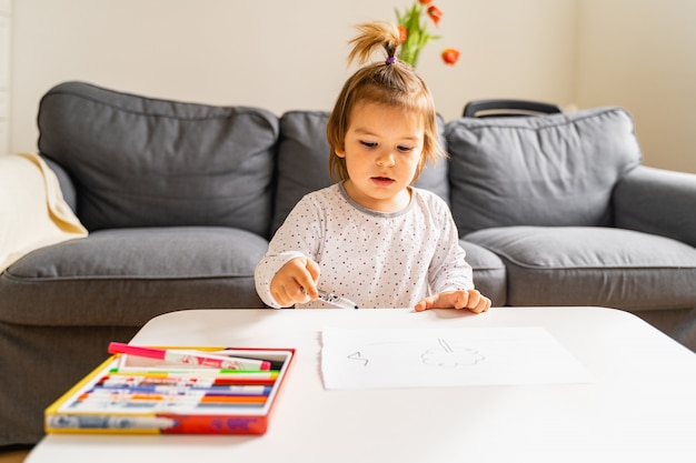 Petite fille dessin avec feutre à la maison