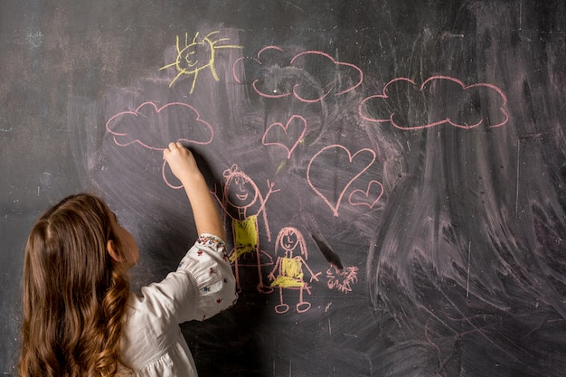 Petite fille dessin mère et fille sur tableau noir