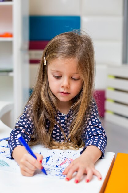 Petite fille dessinant à la salle de jeux