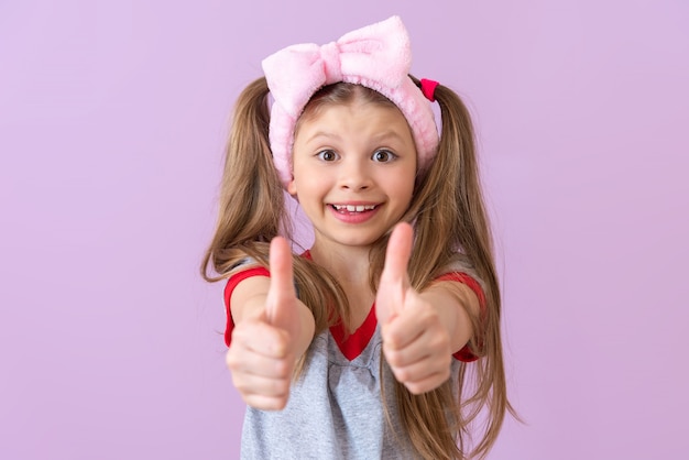 La petite fille donne un coup de pouce très surpris. C'est parfait.