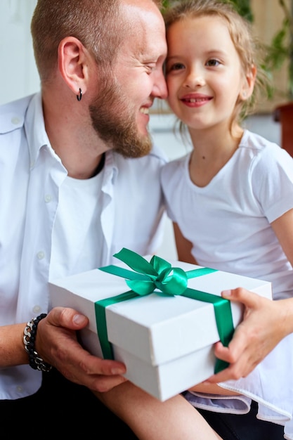 Petite fille donne à son beau père une boîte-cadeau le jour de la fête des pères