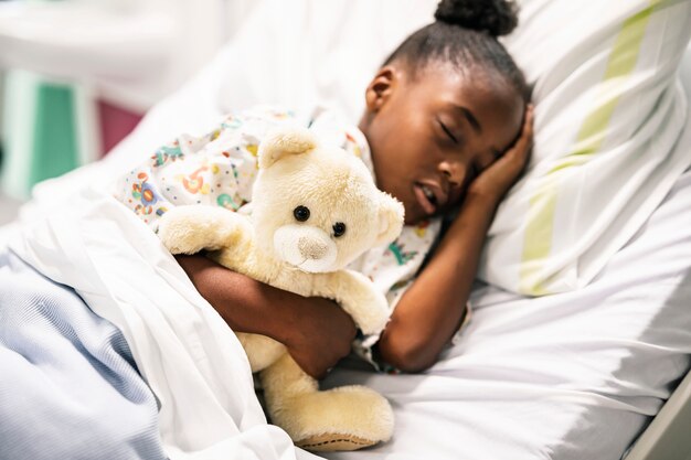 Petite fille dormant dans un lit d&#39;hôpital