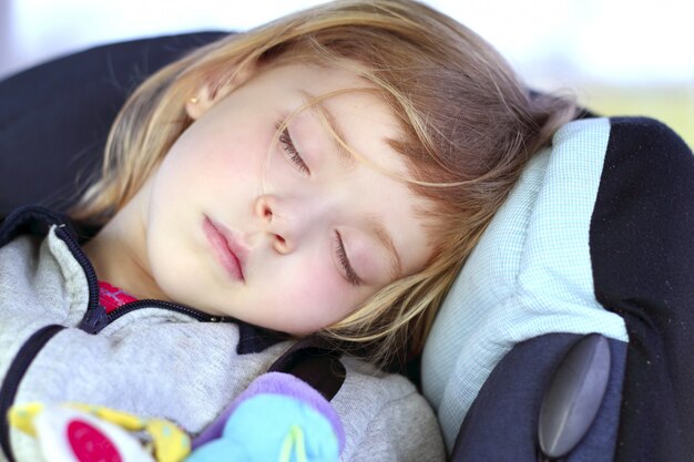 Petite fille dormant sur le siège auto
