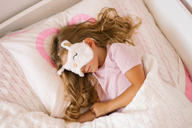 Une petite fille douce qui fait une sieste saine au lit.