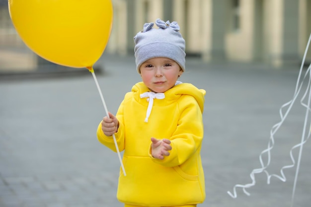 Une petite fille drôle avec un ballon Un bébé de deux ans regarde la caméra