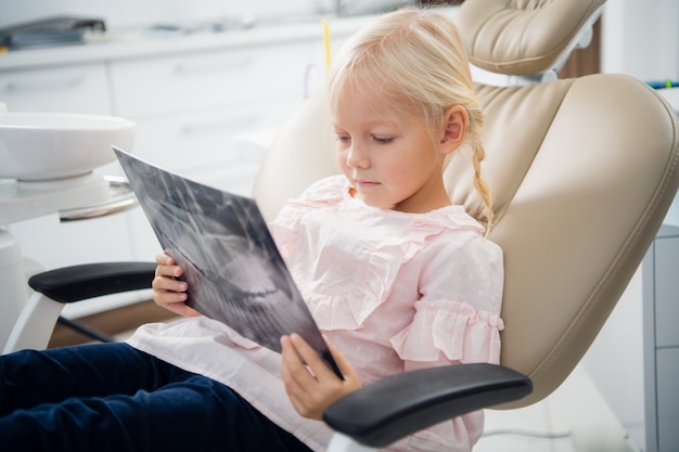 Une petite fille à l'écoute d'un médecin en la regardant ses rayons x