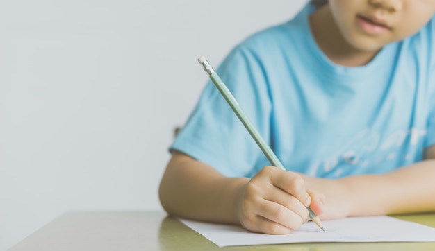 Photo petite fille écrit dans la salle de classe