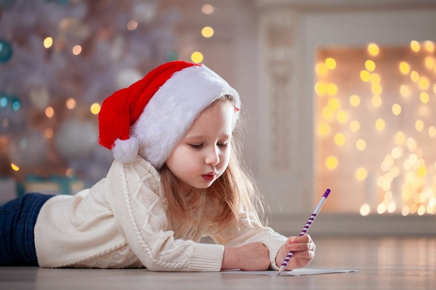 Petite fille écrivant une lettre au père Noël