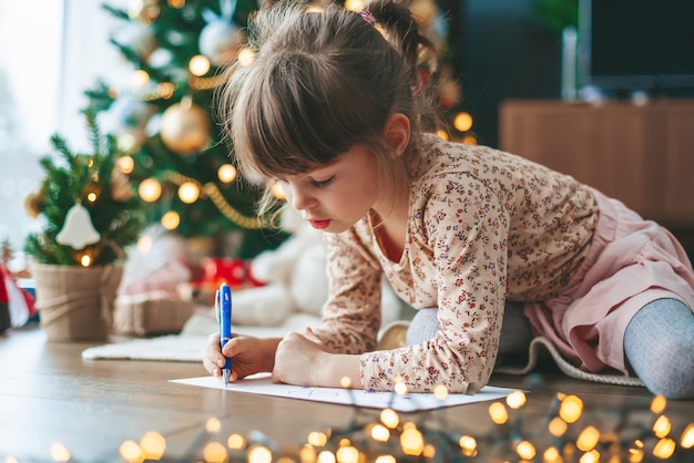 Petite fille écrivant une lettre au père Noël