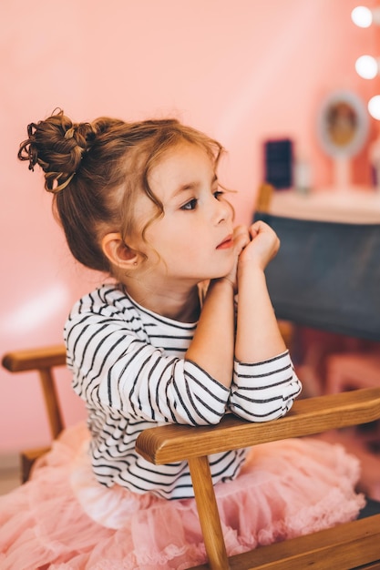 Petite fille élégante dans un salon de beauté pour enfants où elle a fait une belle coiffure