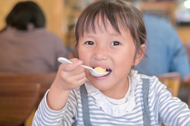 Petite fille enfant asiatique en train de déjeuner sur la table au restaurant