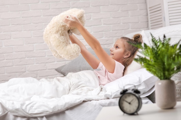 Photo petite fille enfant jouant avec un ours en peluche