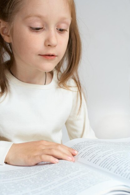 Petite fille enfant lisant un livre. Portrait en gros plan