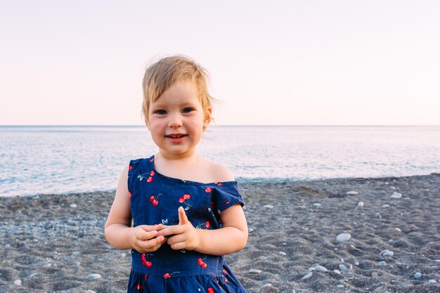 Petite fille enfant mignonne jouant au bord de la mer en été