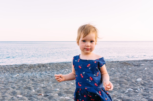 Petite fille enfant mignonne jouant au bord de la mer en été