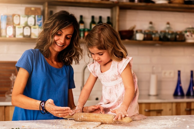 Petite fille enfant pétrir la pâte se préparer pour la cuisson des biscuits. Concept de chef infantile.