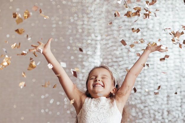 Petite fille enfant en robe de princesse sur fond de confettis