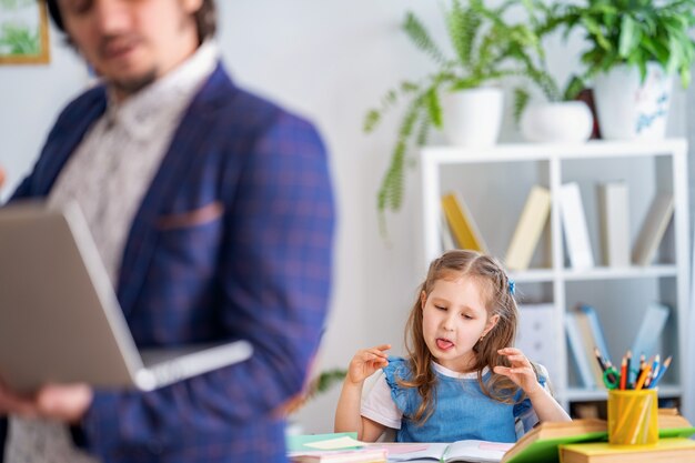 Petite fille engagée dans des leçons avec un enseignant à la maison