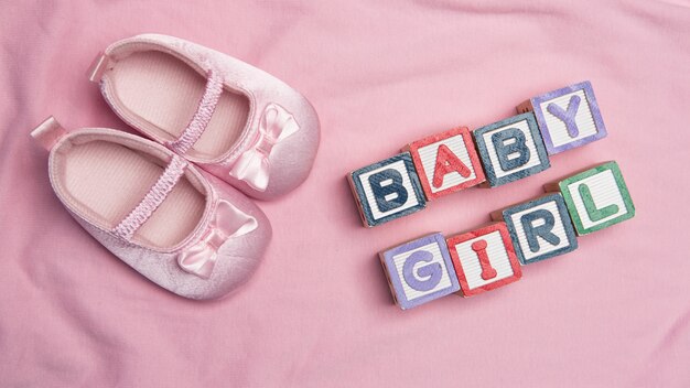 Photo petite fille épelée en blocs avec des chaussons roses