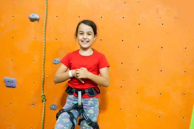 Petite fille escalade mur de pierre