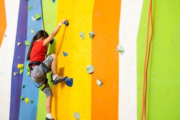 Petite fille escalade mur de pierre