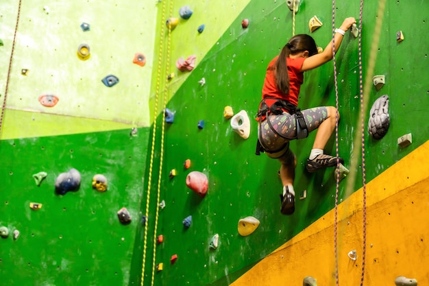 Petite fille escalade mur de pierre