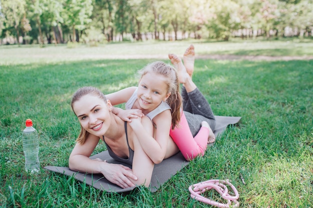 Petite fille est allongée sur le dos de sa maman