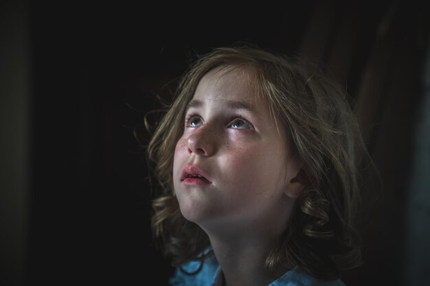 Une petite fille est assise seule dans un couloir sombre peur de la solitude