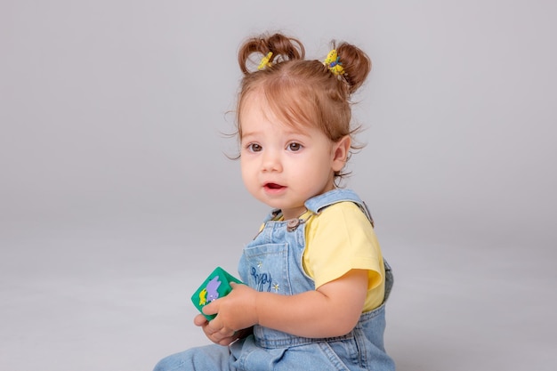 petite fille est sur un fond blanc et joue avec des cubes colorés des cubes de jouets pour enfants