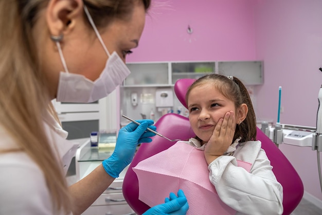 Une petite fille est venue chez le dentiste avec un mal de dents pour un traitement