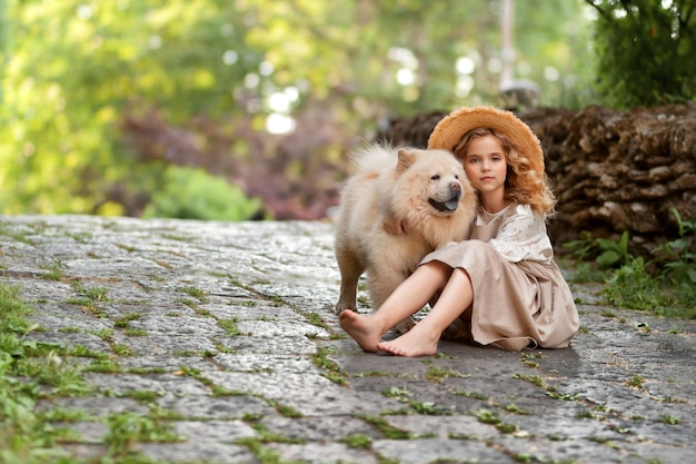 Photo petite fille étreignant un chien rouge