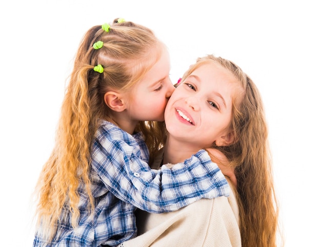Petite fille étreignant et embrassant sa soeur plus âgée