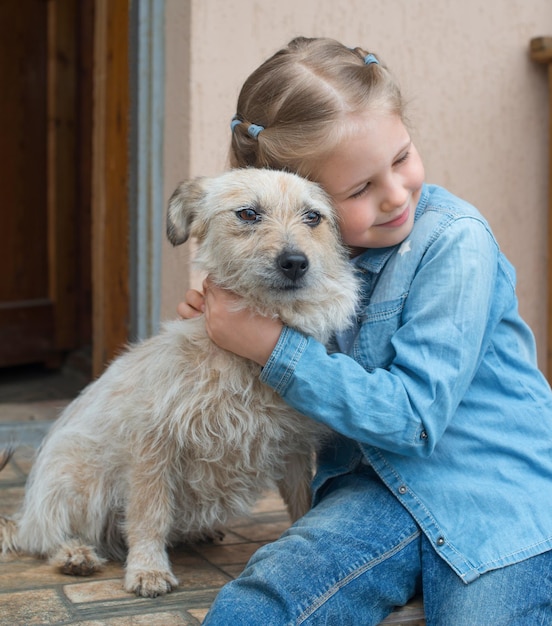 Petite fille étreignant son ami chien à l'extérieur