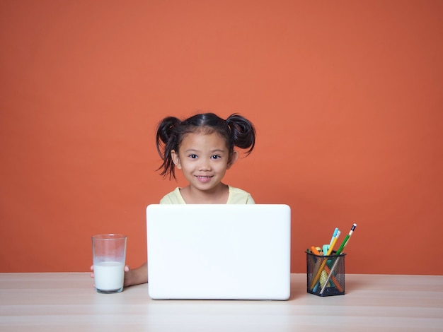 Petite fille étudiant avec un ordinateur portable