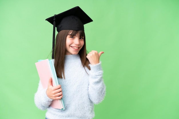 Petite fille étudiante caucasienne sur fond isolé pointant vers le côté pour présenter un produit