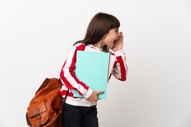 Petite fille étudiante isolée sur fond blanc criant avec la bouche grande ouverte sur le côté