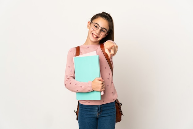 Petite fille étudiante sur mur isolé pointant vers l'avant avec une expression heureuse