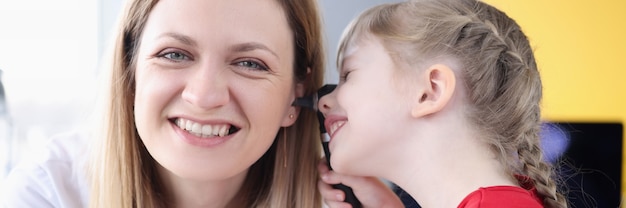 Petite fille examinant l'oreille du médecin dans le diagnostic clinique et le traitement des maladies de l'oreille en