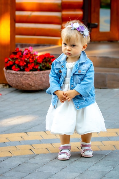 Petite fille avec une expression triste près des fleurs